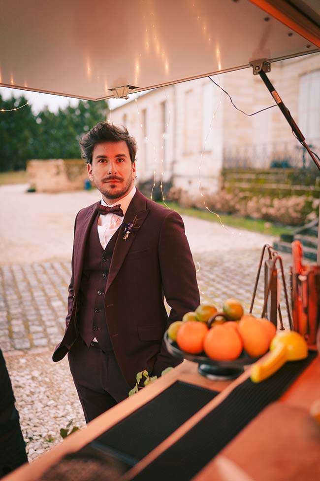 Un jeune marius dans un costume élégant et un panier de fruits frais offrant une touche de couleur à la scène.