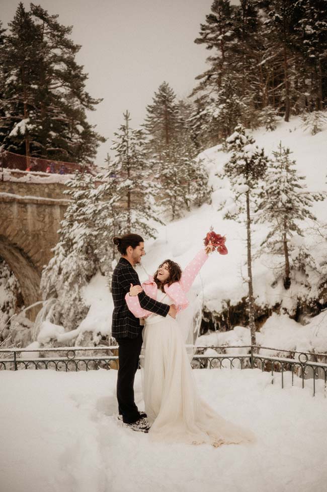 Un couple heureux dans un décor magique de neige, avec la femme tenant un coeur rose, incarnant l'ambiance douce et