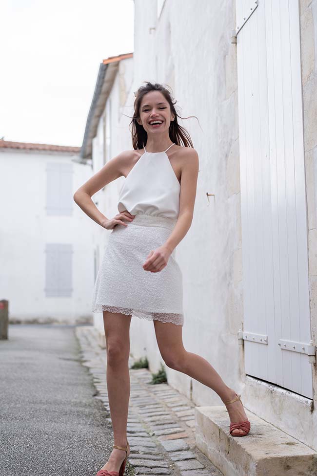 Une jeune femme éclatante dans une robe blanche élégante et délicatement brodée, se baignant dans l'ambiance rassurante