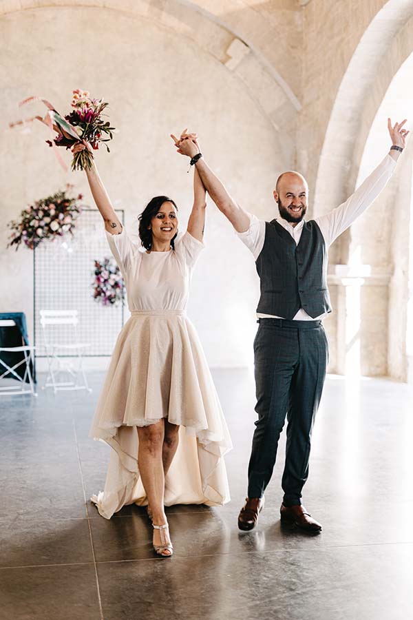 Une mariée et son mari dans des tenues élégantes dans un décor romantique, idéal pour un mariage coloré avec