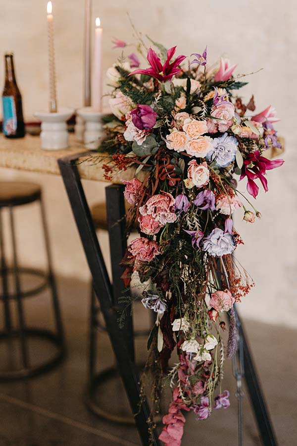Un bouquet vibrante de fleurs colorées se déchaîne sur une chaise, créant un décor romantique pour un mariage pop folk.