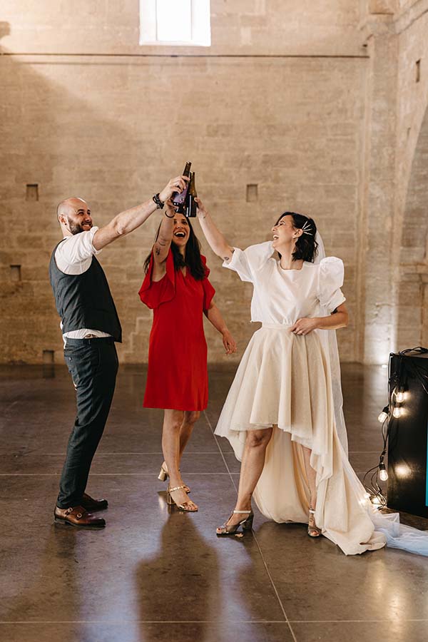 Une scène joyeuse d'un couple de mariés dans des vêtements colorés, capturée par un photographe dans un décor rustique romantique.