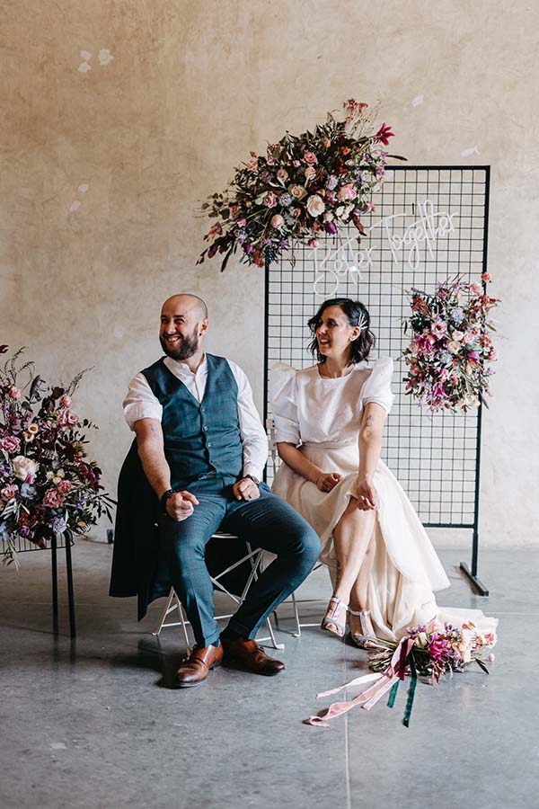 Un couple heureux dans un décor romantique avec des fleurs colorées et une atmosphère chaleureuse.