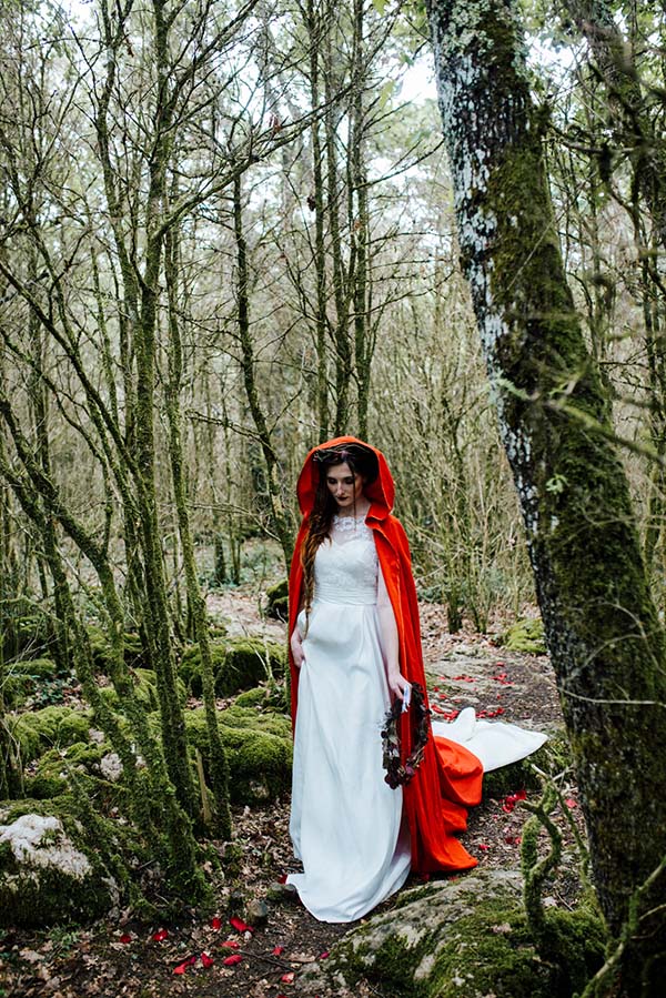 Magique scène dans un bois verdoyant, avec une mariée en blanc et cape rouge, inspirée du conte de Perrault.