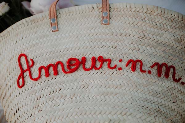Un sac en osier élégant orné de l'inscription "Amour : m." en rouge, idéal pour un mariage en bord de mer en Pays de Loire.