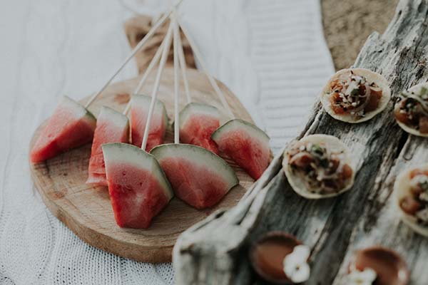 Savoureuses brochettes de melon frais et une sélection de petits plats délicieux, idéaux pour une réception en bord de