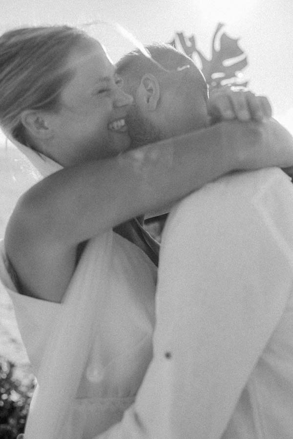 Un couple heureux dans des costumes de mariée et de mari, partageant un moment tendre à bord de mer dans la région de la Loire.