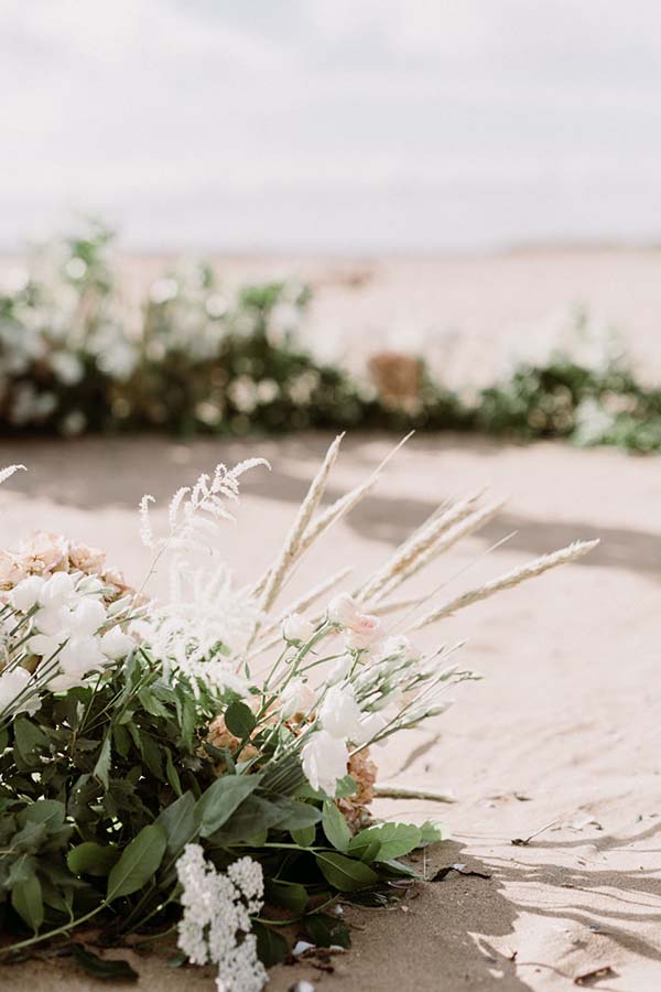 Magnifique bouquet de fleurs blanches et roses sur la plage, idéal pour un mariage en bord de mer dans le Pays de Loire.
