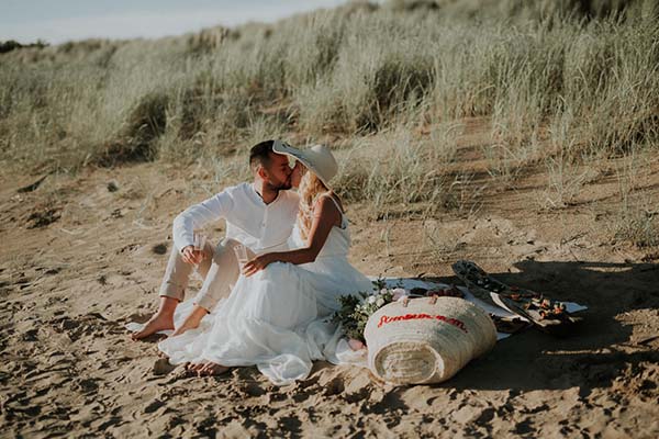 Un couple heureux en blanc et blanc, partageant un moment intime sur la plage paisible de la Côte de la Loire.