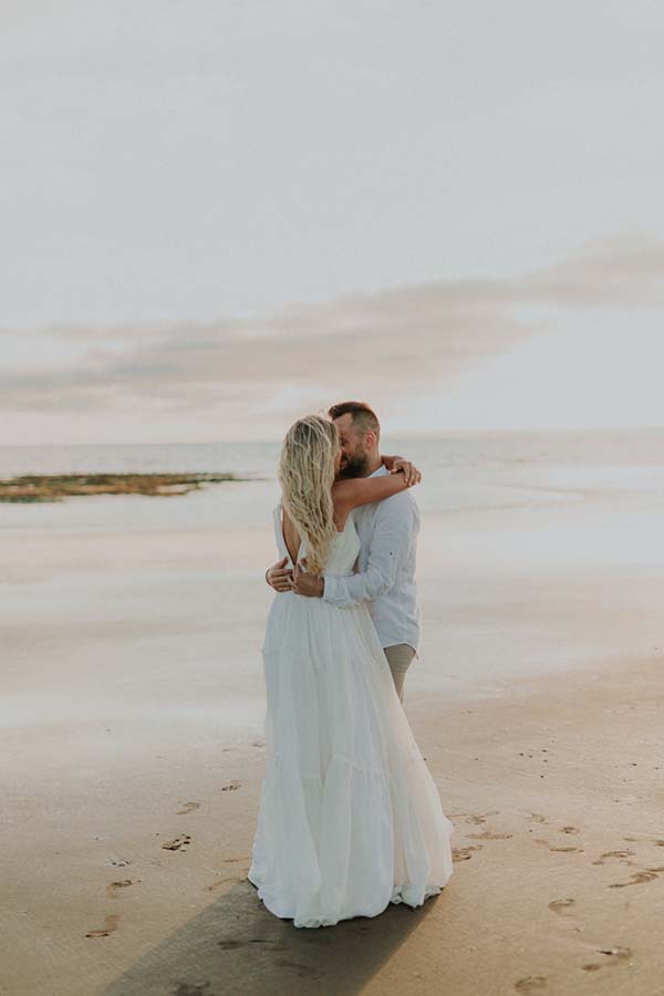 Un couple romantique se baigne dans l'ambiance paisible d'un coucher de soleil sur la plage de la Côte de la Loire.