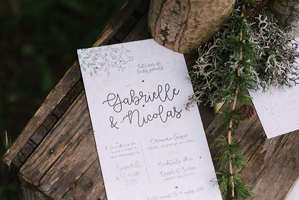 Un programme de mariage élégant avec des illustrations naturelles, suggérant un mariage en plein air dans les Alpes du Rhône.