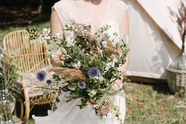 Un bouquet de fleurs rustiques et élégantes dans une scène romantique de mariage en plein air dans la région de Rhône-Alpes.