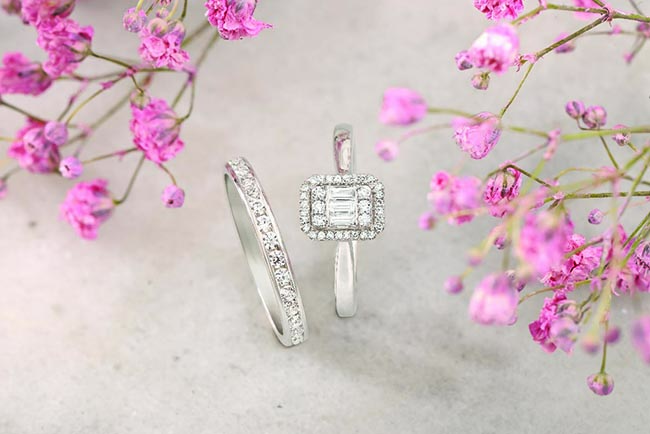 Magnifique ensemble de bagues et de戒 avec des diamants délicieux, entourés de fleurs roses, idéal pour un mariage romantique.