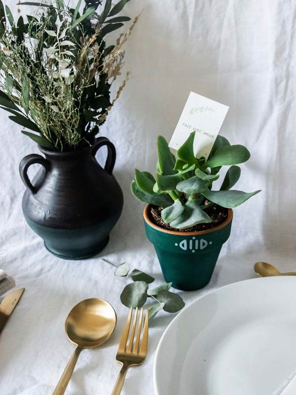 Tableau de mariage élégant avec fleurs vertes et potager, accompagné de potager vert et de fourchettes or pour un toucher de chic.
