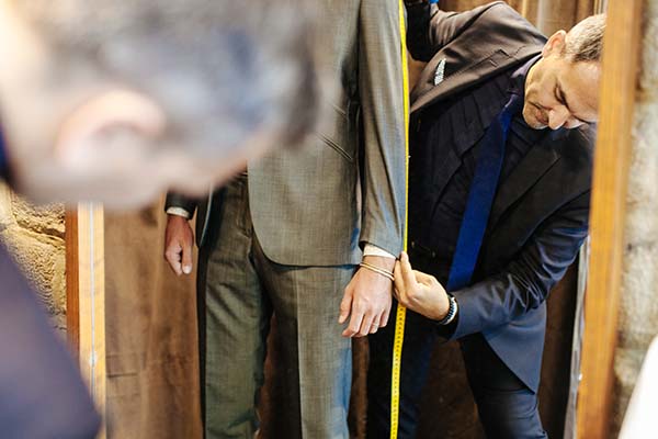 Tailleur en costume mettant mesures pour un mariage élégant.