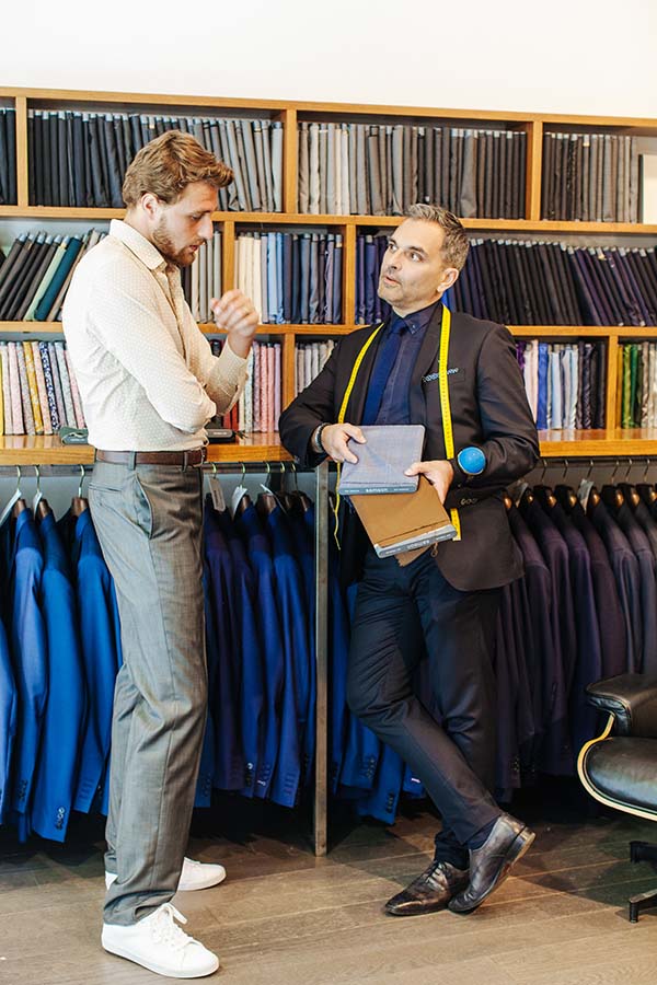 Conseils d'un tailleur professionnel dans un magasin de costumes riche en couleurs.