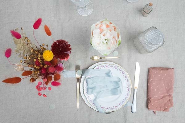 Table soignée avec fleurs et plats colorés, idéale pour un mariage romantique.