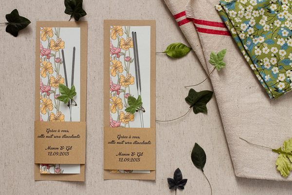 Deux marque-places personnalisés avec baguettes et fleurs jaunes, entourés de feuilles vertes sur fond clair.