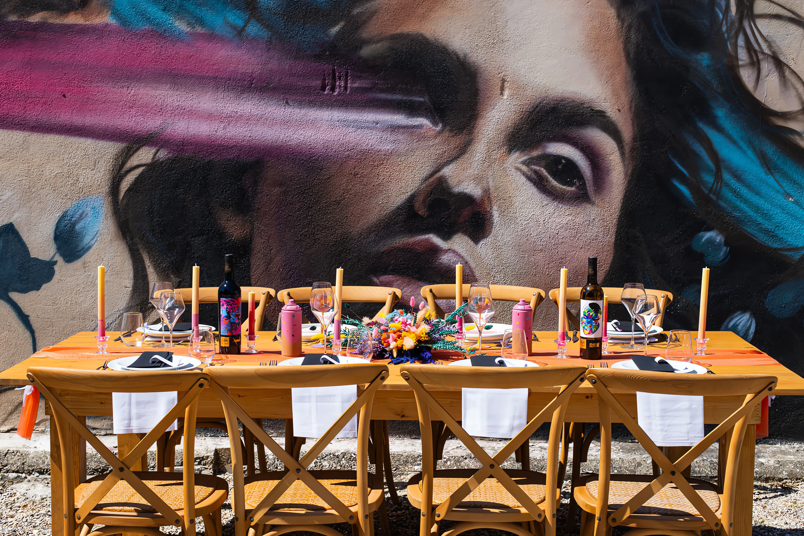 Table de mariage élégante dressée devant un immense graffiti coloré et moderne.
