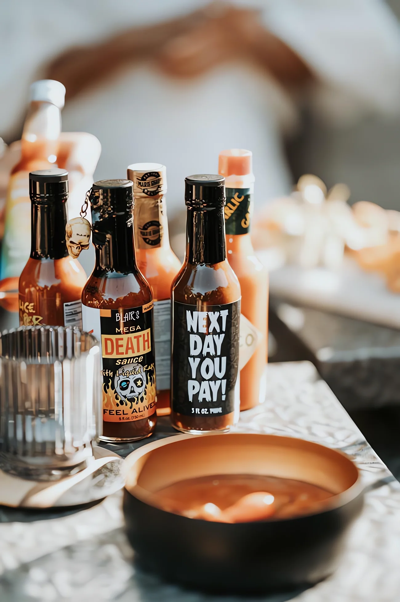 Plusieurs bouteilles de sauces pimentées colorées posées sur une table pour un mariage au thème épicé.