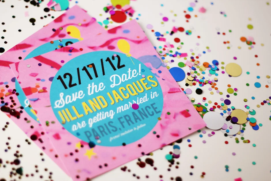 Cartes Save the Date roses et bleues entourées de confettis multicolores pour un mariage à Paris.
