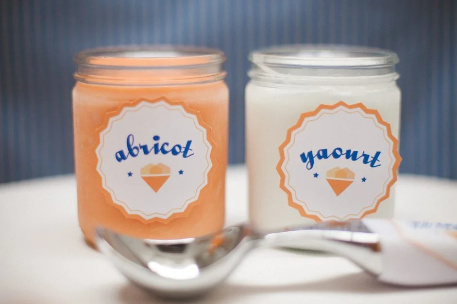 Deux pots de sorbet abricot et yaourt avec des étiquettes personnalisées pour un bar à glaces.