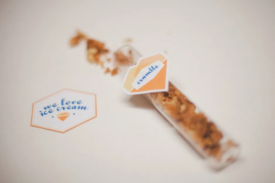 Tube à essai rempli de crumble avec étiquettes pastel pour un bar à glaces DIY.