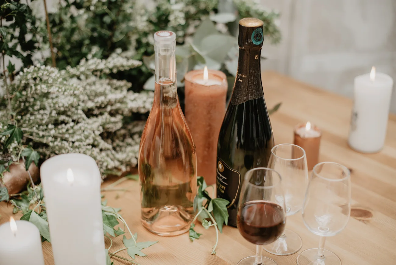 Évocation romantique d'un mariage avec une sélection soignée de vins et de décorations floraux.