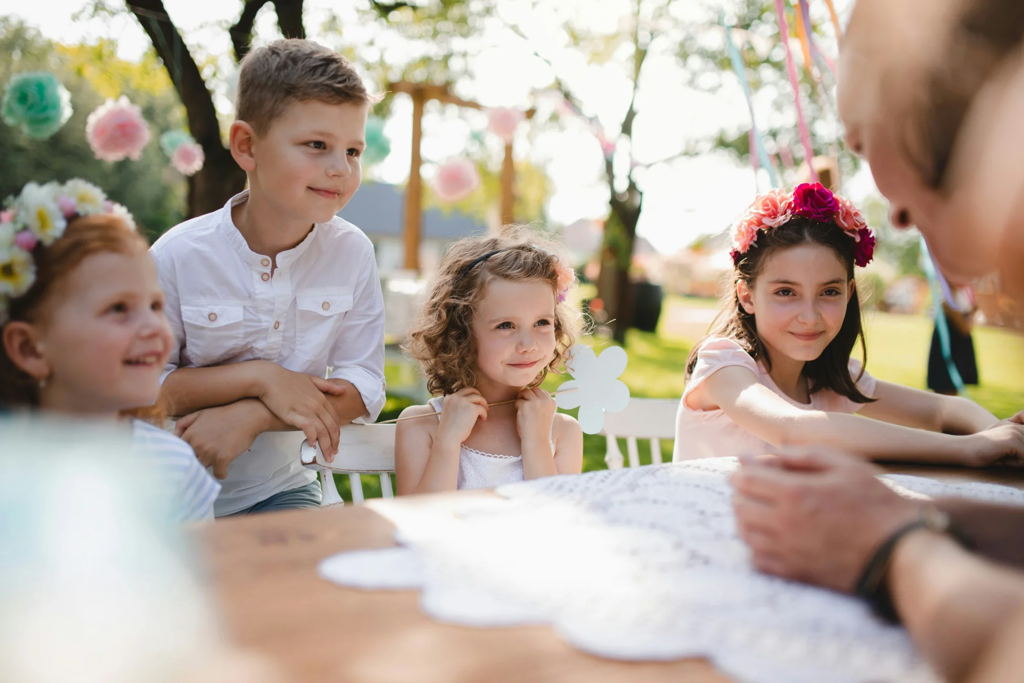 Une réunion joyeuse d'enfants au mariage, assis autour d'une table décorée de fleurs, avec un décor coloré et ludique.