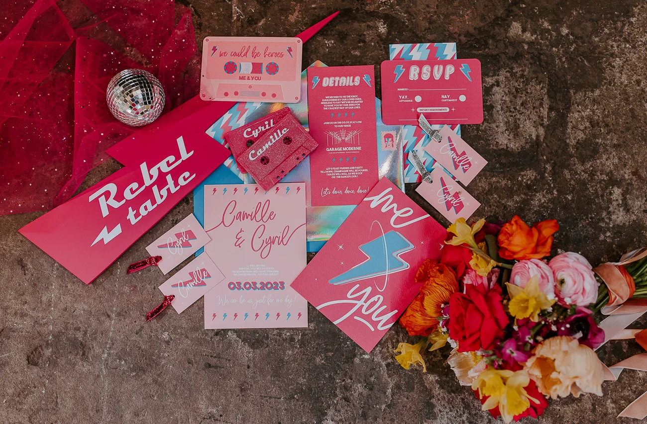 Un événement romantique avec un thème pink Bowie, des invitations créatives et une bouquet coloré.