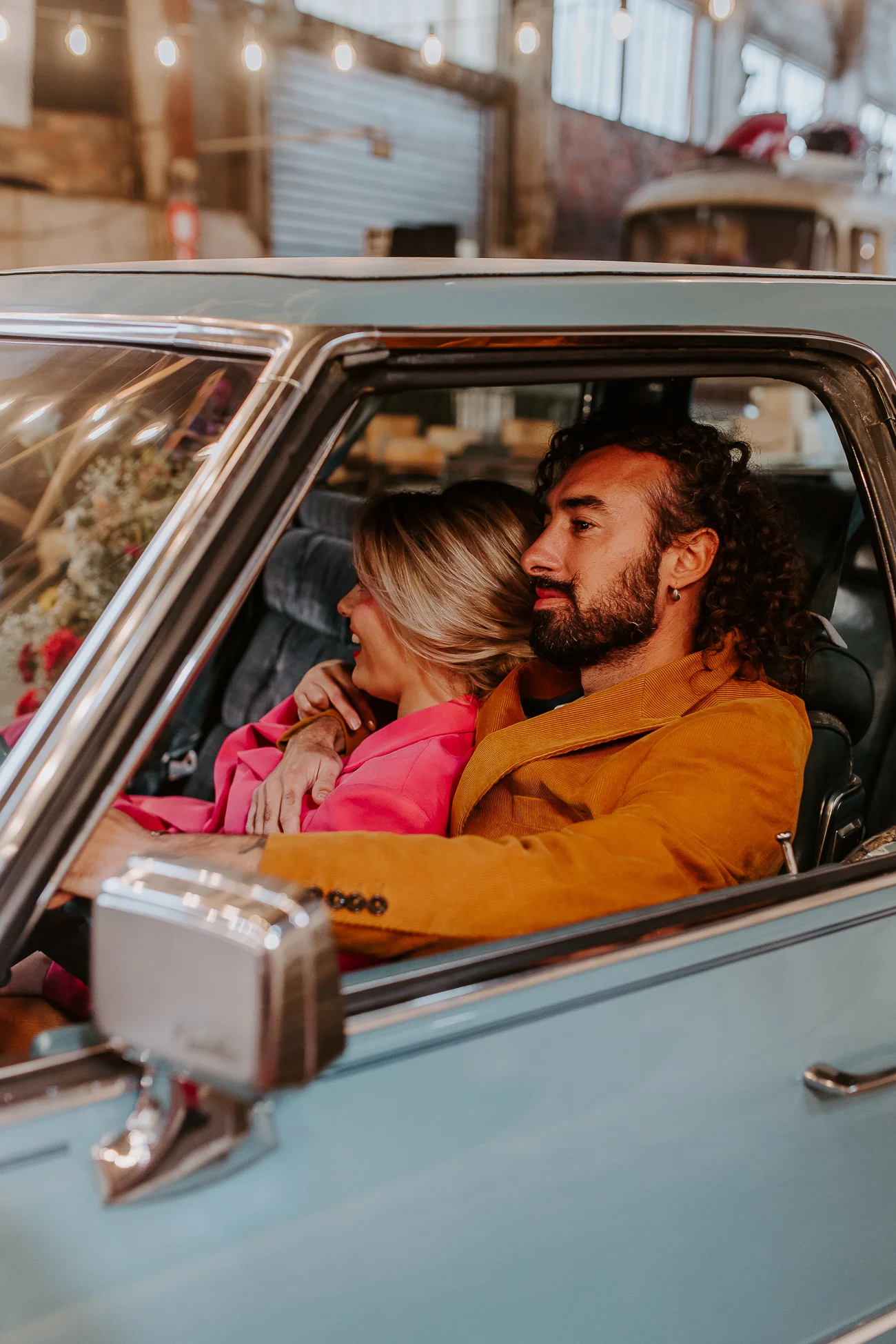 Un couple émerveillé dans une voiture bleue vintage, un toaster anachronique ajoutant un toucher de fantaisie.