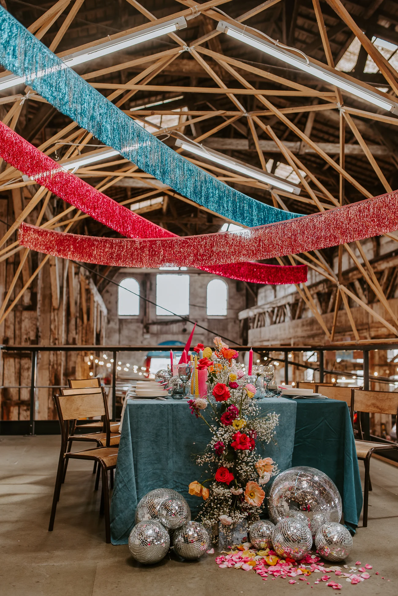 Un mariage étonnant avec des cordons de paillettes bleu et rouge, une table de fête décorée de fleurs colorées et de
