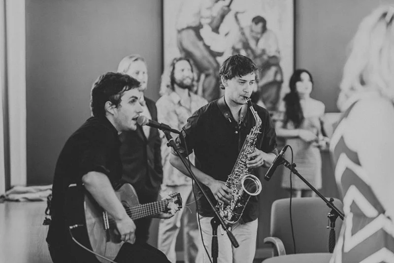 Groupe de musique jouant du saxophone et de la guitare lors du mariage de Jade et Sully, photo en noir et blanc.