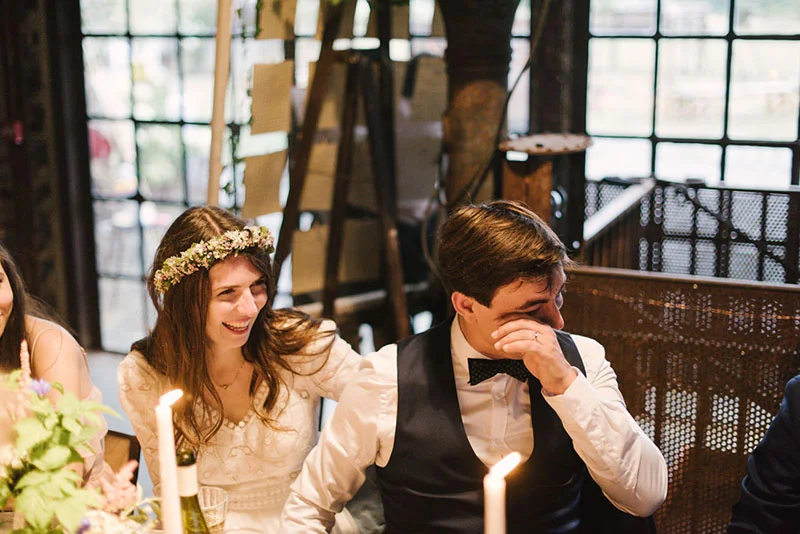 Mélanie et Jonathan partagent un moment d'émotion lors de leur dîner de mariage dans un cadre industriel et chaleureux.
