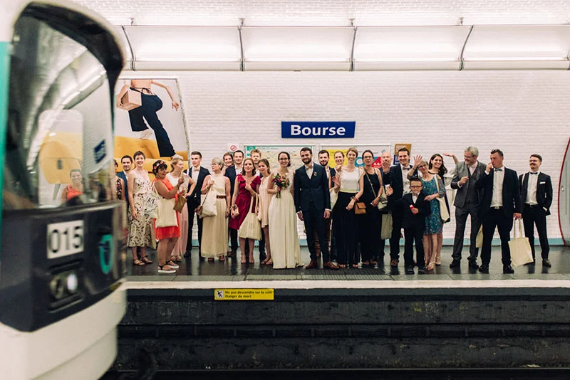 Mariés et invités élégants posant avec complicité sur le quai de la station de métro Bourse à Lille.