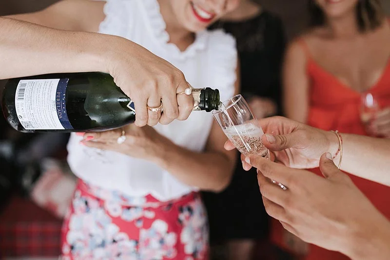 Une main verse du champagne dans une flûte lors d'une célébration festive et élégante.