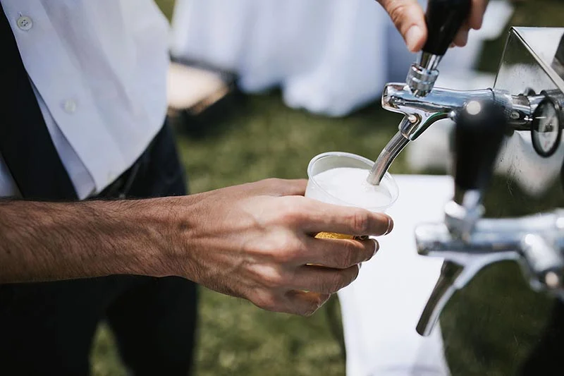 Un serveur verse de la bière fraîche dans un verre lors du mariage de Pauline et Florent.