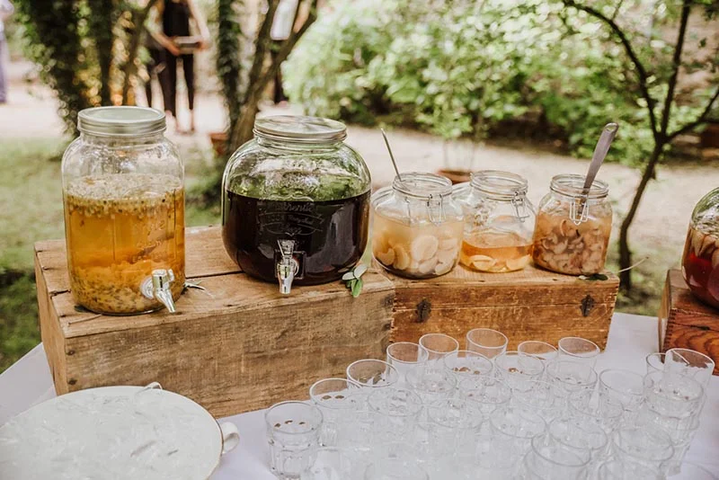 Bonbonnières de boissons rafraîchissantes colorées sur un caisson en bois pour le cocktail d'Aline et Thierry.