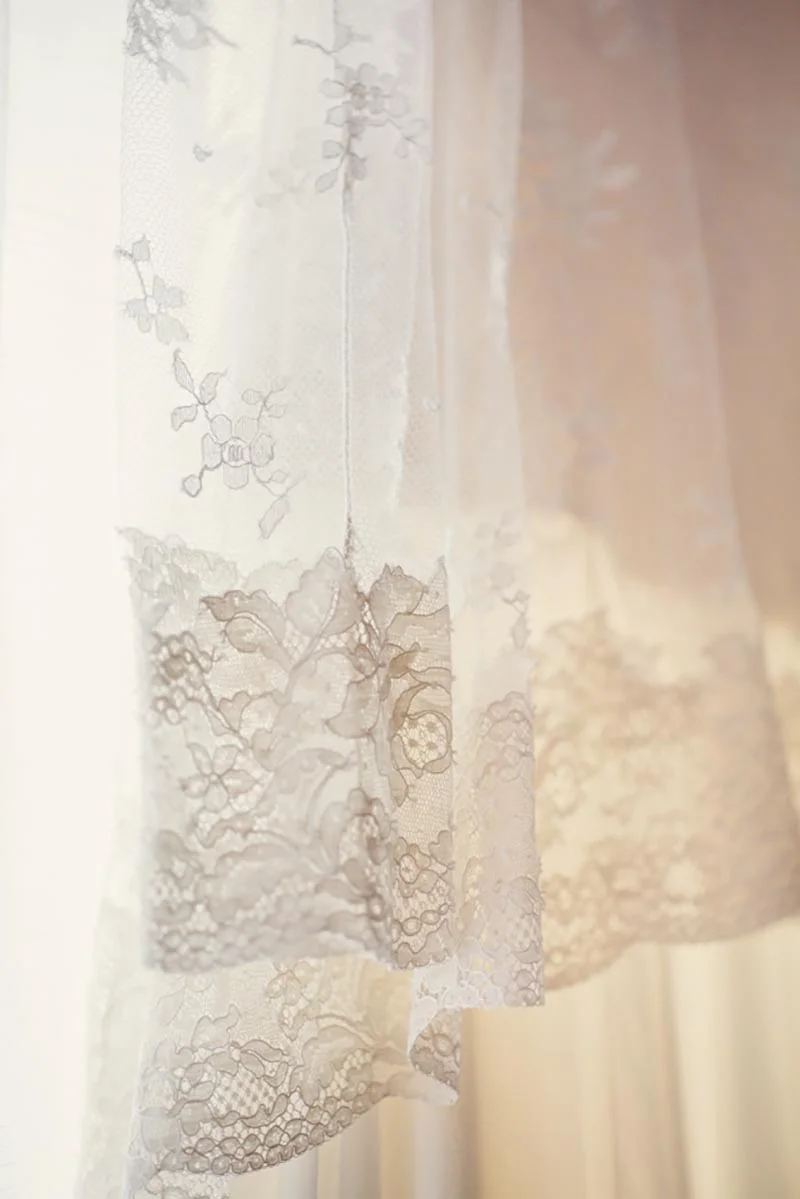 Gros plan lumineux sur les détails en dentelle blanche et délicate d'une robe de mariée.