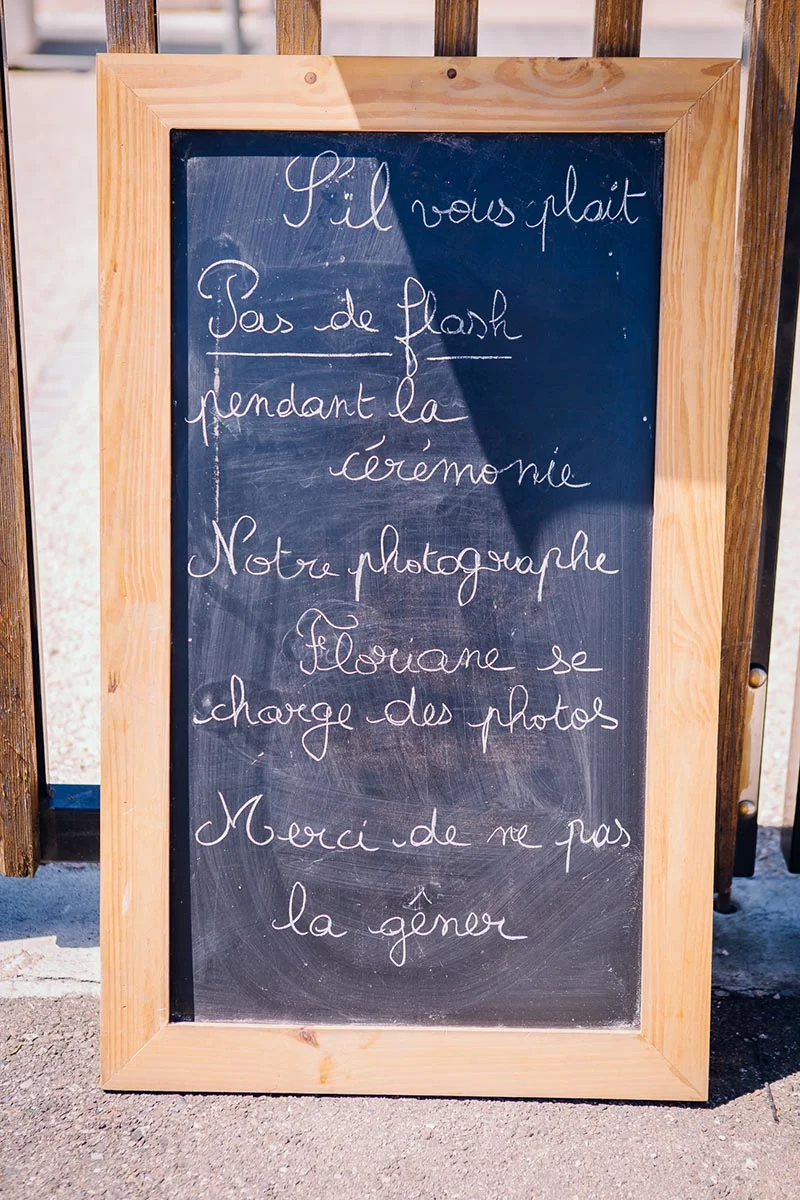 Ardoise encadrée de bois demandant poliment de ne pas utiliser de flash pendant la cérémonie de mariage.