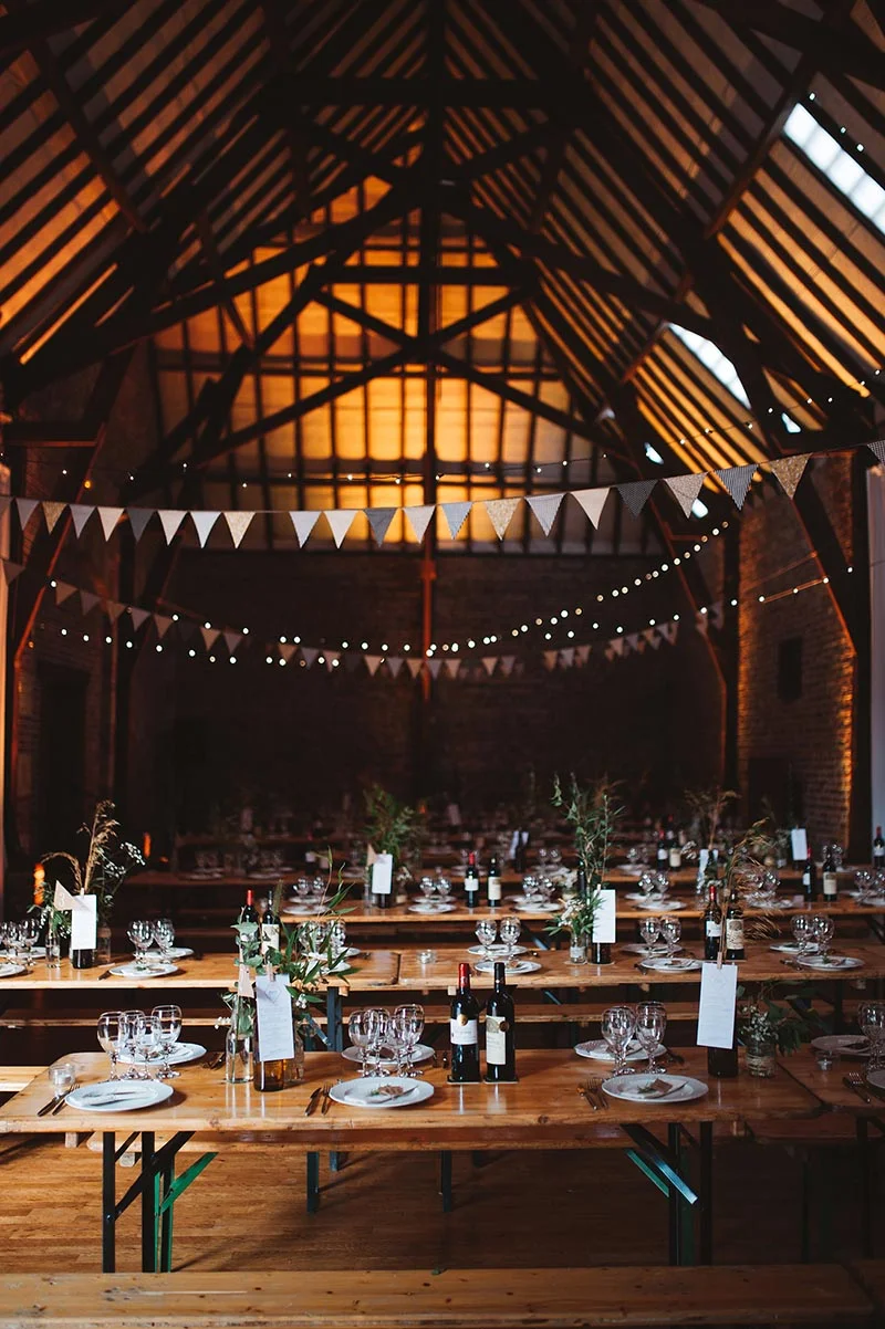 Décoration de table rustique et guirlandes dans une grange chaleureuse pour un mariage homemade.