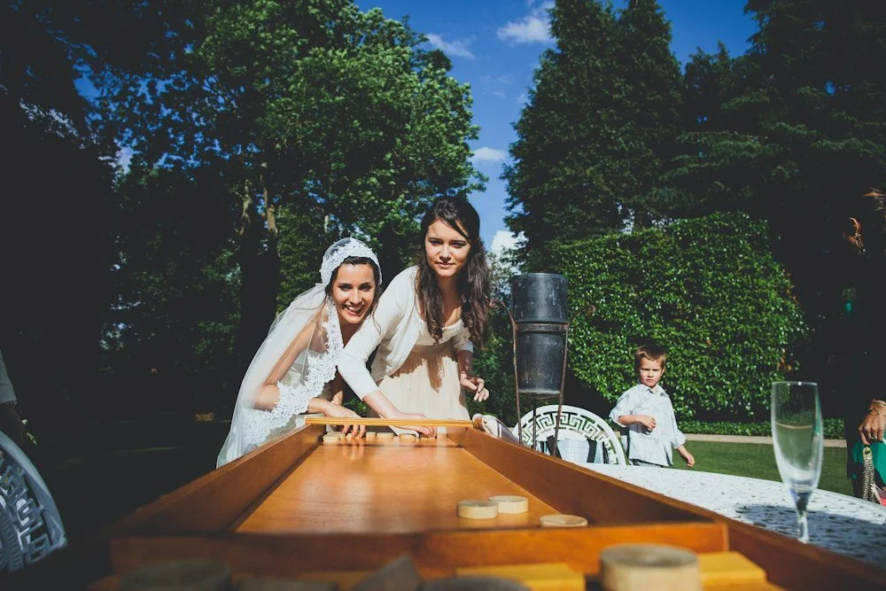 Amis en blanc jouant à l'échec dans un jardin charmant, célébrant un mariage heureux.