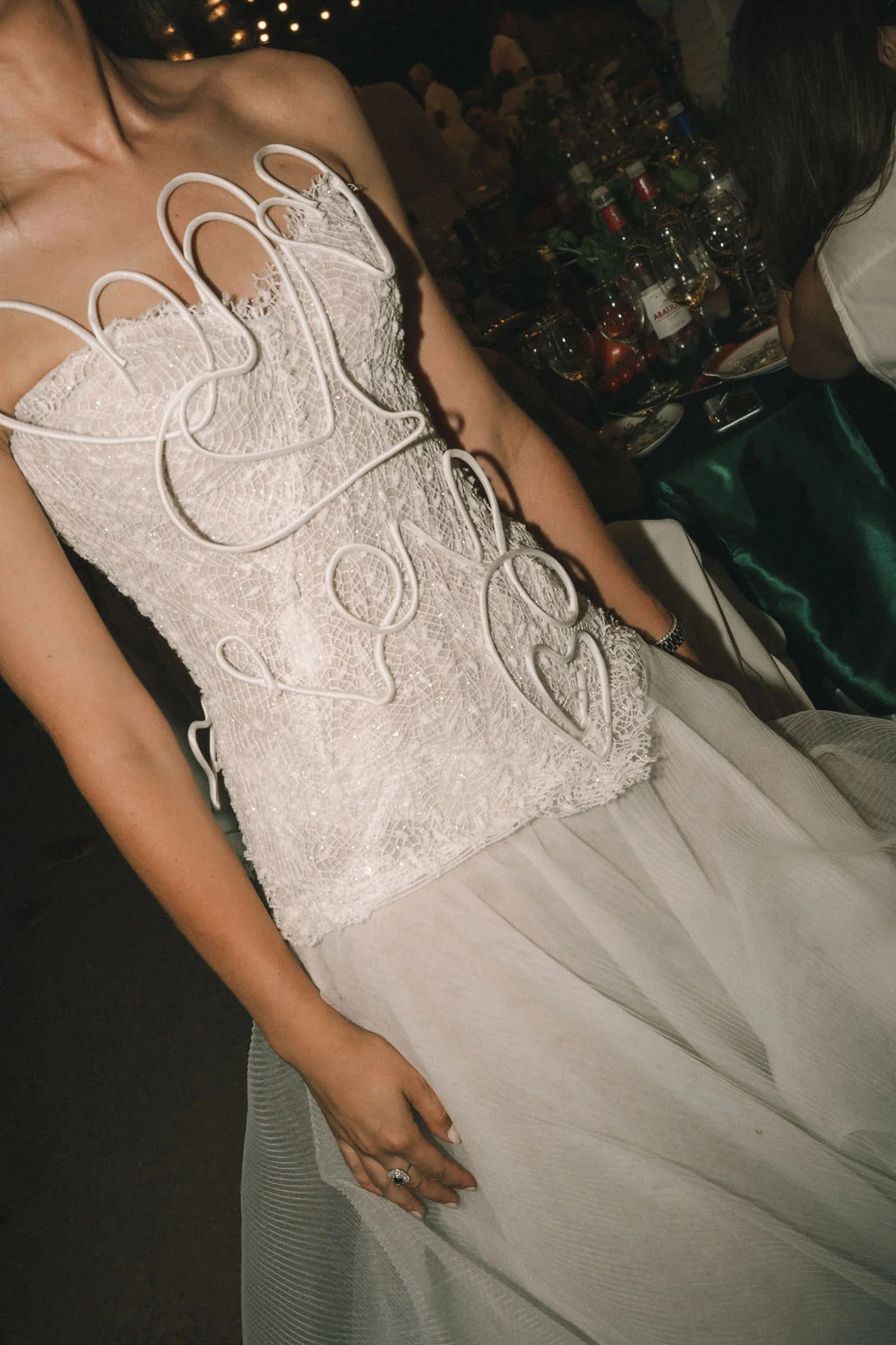 Gros plan sur le bustier en dentelle blanche d'une robe de mariée orné de motifs graphiques en relief.