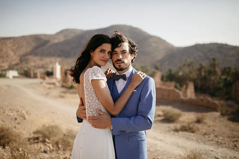 Un couple romantique dans des vêtements élégants contre un décor sauvage et inspirant.