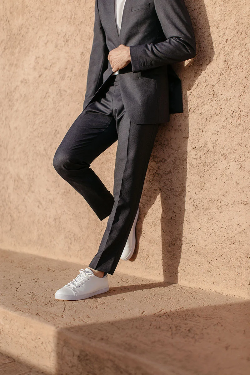 Modeux et audacieux, un costume noir parfaitement coupe avec des chaussures blanches modernes, incarnant l'élégance et