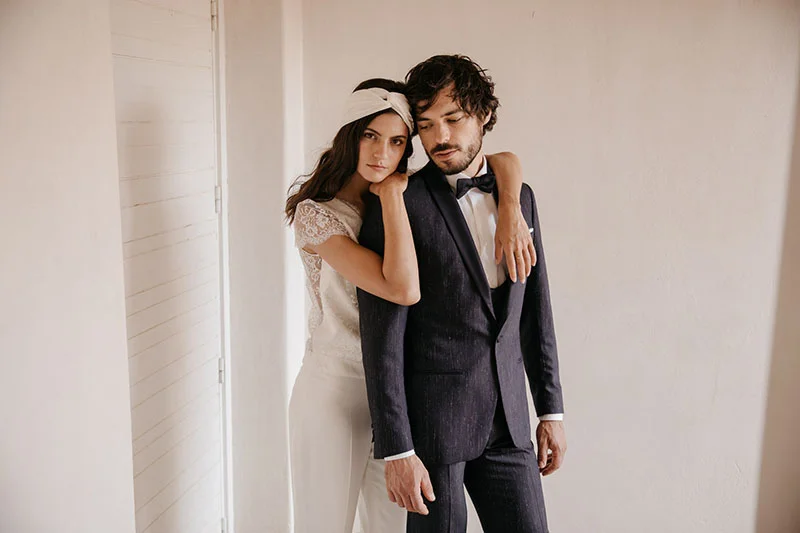 Un couple romantique dans des costumes de mariage classiques avec un toucher d'originalité.