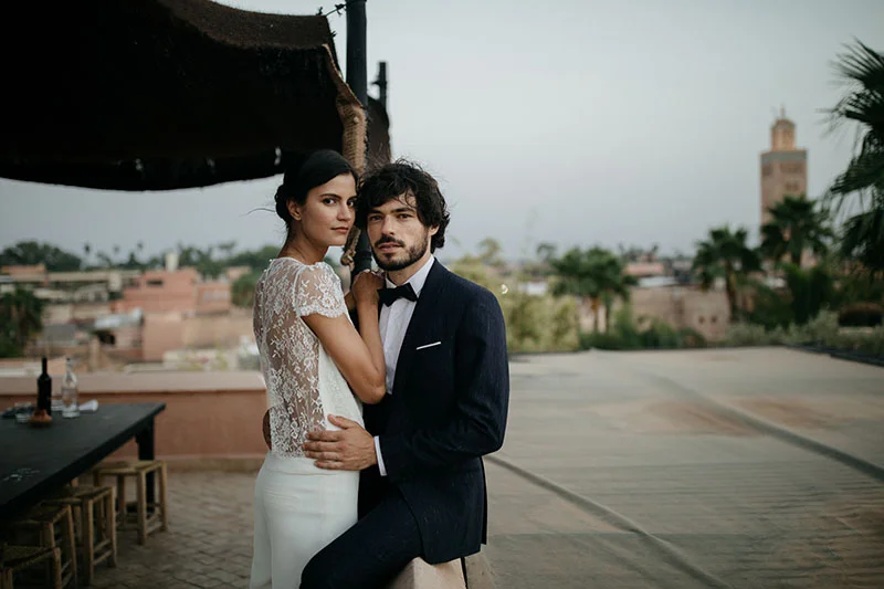 Un couple romantique dans des vêtements de mariage élegants contre un décor pittoresque, incarnant l'élégance et l'originalité.