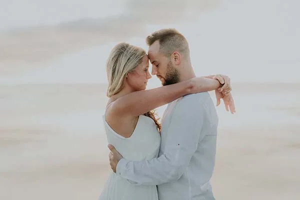 Un couple romantique échange des promesses tendres sur la plage paisible du Pays de Loire.