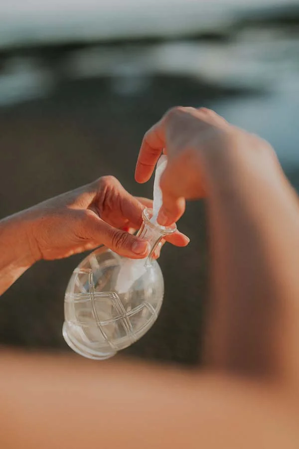 Un couple se prépare pour le mariage en bord de mer, avec un verre de vin transparent et doux ambiance.