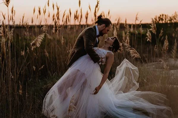 Un couple romantique dans un champ de pampes, célébrant leur mariage dans un décor naturel et éco-responsable.